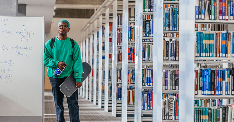 Person in a green sweater walking through a library